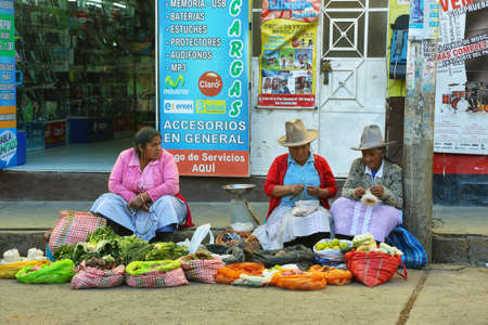 HUARAZ, PERU - JUNE 5: women selling herbs and fruits in small stall in a commercial street of Huaraz city on June 5, 2017 in Huaraz, Ancash province, Peruのeditorial素材