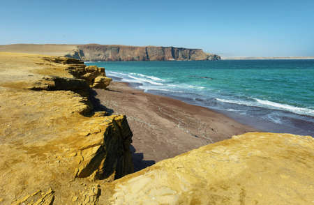 The coast and red sand beach of Paracas National Reserve in Peru