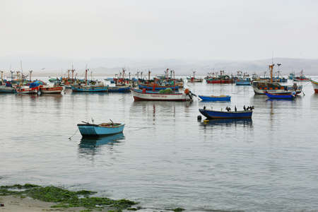 Paracas, Peru - June 16, 2017: Peruvian birds and boats in Paracas pier in a cloudy morning in Paracas, Ica, Peruのeditorial素材