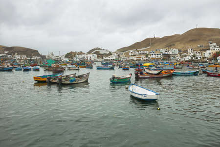 Pucusana, Peru - June 17, 2017: Peruvian fishermen boats in Pucusana pier in a cloudy morning in tourist town of Pucusana close to Lima, Peruのeditorial素材