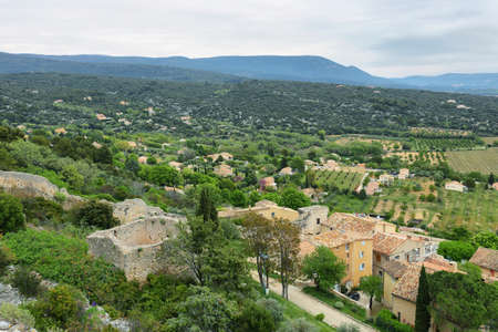 View of houses and surrounding fields in St Saturnin les Apt, town in Franceの写真素材