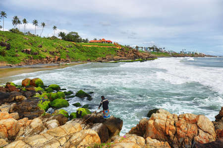 Kovalam, India - September 25, 2019: fisherman with colorful dress fishing in Kovalam, Kerala, Indiaのeditorial素材