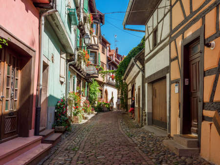 Eguisheim, France - July 18, 2021: Street with colorful traditional french houses in Eguisheim town of Alsace region, Franceのeditorial素材