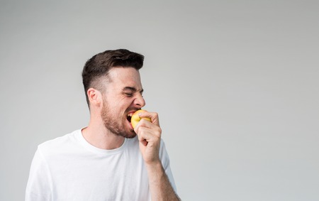 bearded man holding an apple vegetarian preparing dinner