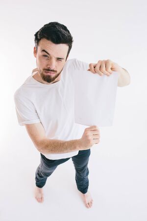 Bearded man holding a blank white sheet of paperの写真素材