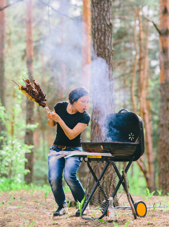 woman preparing meat on the grillの写真素材