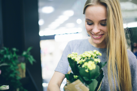 Young woman buying flowers at a garden centerの写真素材