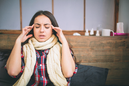 Young beautiful Caucasian woman on bed having headache insomnia migraine stress.の写真素材