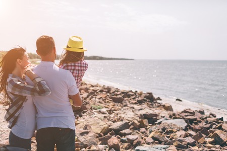 Happy family on the beach. People having fun on summer vacation. Father, mother and child against blue sea and sky background. Holiday travel concept.の写真素材