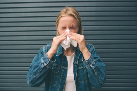 picture from a young woman with handkerchief. Sick female model has runny nose.の写真素材