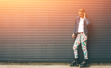 Pretty blonde girl posing with roller skates outdoors. Summer lifestyle portraitの写真素材