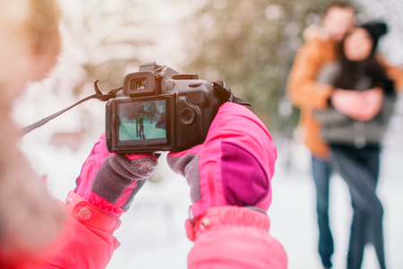 Parenthood, fashion, season and people concept - happy family with child in winter clothes outdoors. Take photos with each otherの写真素材