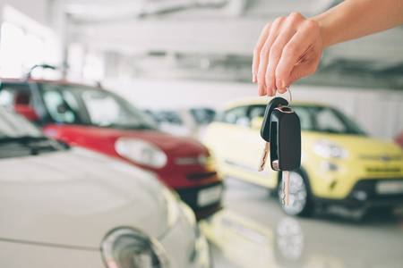 Passing car keys. Cropped closeup of a car dealer holding out car keys to the camera copyspace car dealership salon manager salesman selling buying giving owner profession purchase vehicle conceptの写真素材