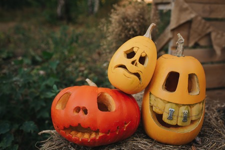 Ghost pumpkins on Halloween. head Jack on an autumn background. Holiday outdoor decorationsの写真素材