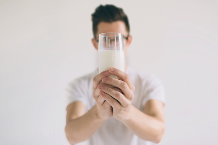 man is drinking fresh glass of milk isoladed on white backgroundの写真素材
