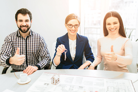 Young family couple purchase rent property real estate . Agent giving consultation to man and woman. Signing contract for buying house or flat or apartmentsの写真素材