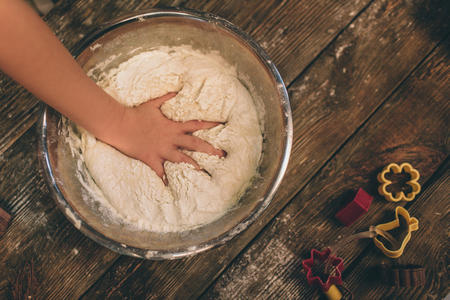 Cooking homemade cakes. Happy loving family are preparing bakery together. Mother and child daughter girl are cooking cookies and having fun in the kitchen. Roll the dough. hand close-upの写真素材