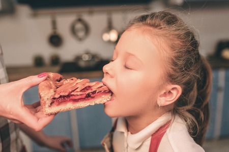 Cooking homemade cakes. Happy loving family are preparing bakery together. Mother and child daughter having fun in the kitchen. Eat fresh homemade cakeの写真素材