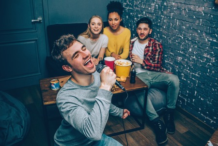 Close up of a guy who is singing a song. He is trying to do it the best as he can.の写真素材