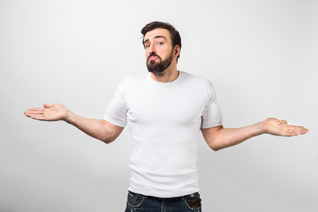 An adult standing near white wall with a sad face and showing that he have nothing with his right now or he doesn't know anything.の写真素材