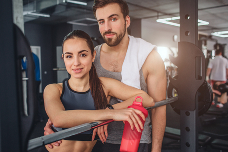 Fantastic couple is standing together in the training room and posing on camera. They look good together. This couple is having some rest after hard workout.の写真素材