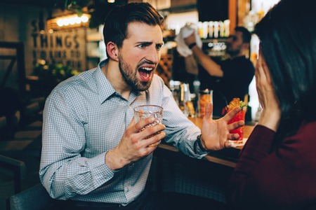 A picture of guy screaming to the girl. He is tired and angry at the same time. She is stressed as well.の写真素材