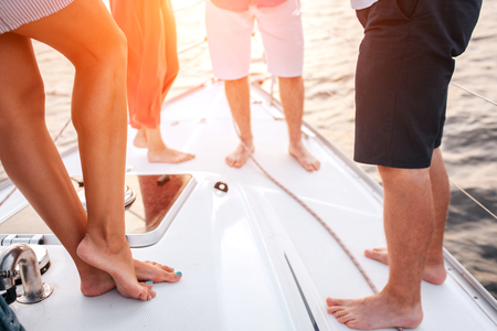Cut view of peoples legs. Two men and two women stand in front of each other. They spend time togetherの写真素材