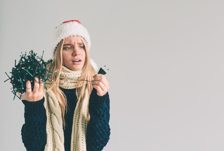 A woman holds electric garlands. They are very confused.