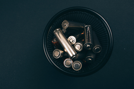 Recycling, reuse, reduce concept. Protect an environment. Single-use silver batteries in the metal box on dark background, close-up. Single-use electric waste. Top viewの写真素材