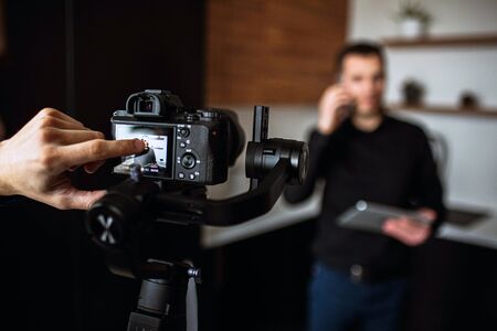 Cameramans finger point on cameras screen. Recording video or taking picture of young buisnessman in...