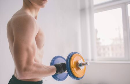 Closeup of a muscular young man lifting weightsの写真素材
