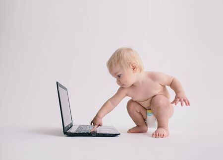 Happy Baby Laughing and Playing with Laptopの写真素材