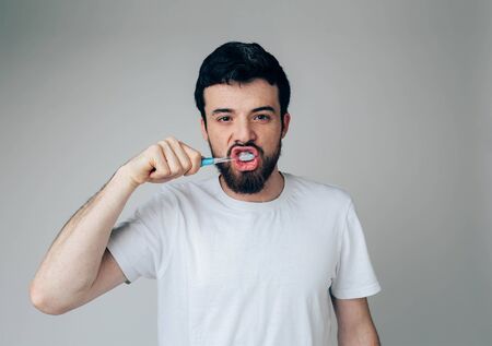 Young man isolated over background. Health and beauty concept - guy with toothbrush healthcare and...