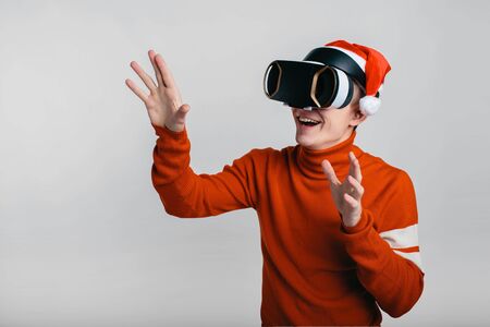 Man wearing virtual reality goggles. Studio shot, gray backgroun