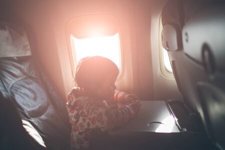 child on the plane looking outside of airplane window.の写真素材