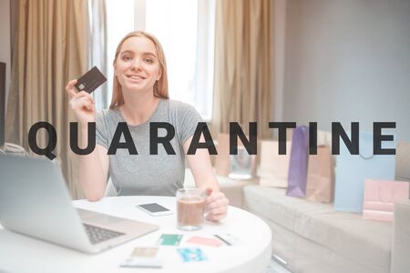 Online shopping at home. Young happy woman is ready to spend money from payment card on black Friday...