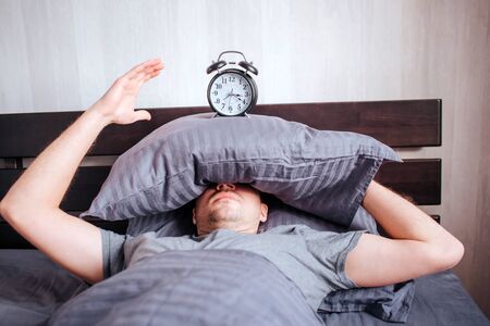 no strength to get out of bed in the morning. A man in the morning in the bed does not want to wake...