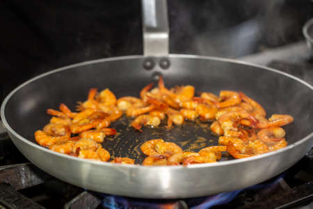 Process of frying shrimp with garlic in olive oil in the black pan. step by step cookingの写真素材