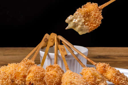 breaded shrimp with sauce on wooden table.の写真素材