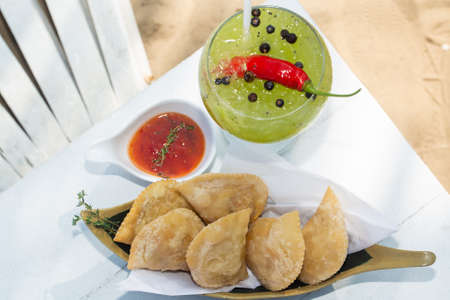 top view of table with tropical cocktail sauce and traditional Brazilian pastry where it is called...