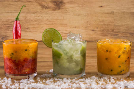 Caipirinha, Brazilian national cocktail made with cachaca, sugar cane liqueur and fruit on wooden...