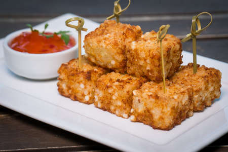 Cubes of cheese and tapioca. Brazilian snack called Dadinho de tapioca  made with rennet cheese and tapioca flour, served with pepper jellyの写真素材