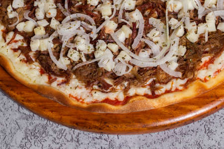 dried meat pizza with onion and heart of palm typical of Brazil where it is called Acebolada dry...
