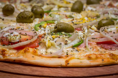 Portuguese Pizza, onion, peppers, pepperoni, egg, olive. Close up.の写真素材
