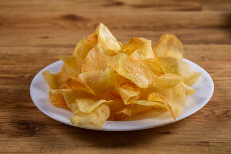 portion of potato chips on wooden background.の写真素材