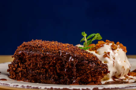 slice of chocolate cake with vanilla ice cream
on blue background.の写真素材