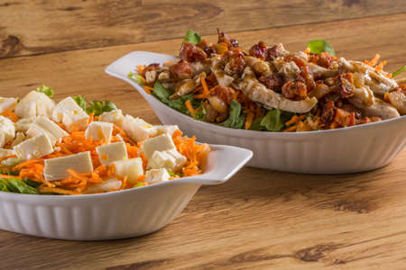 assorted fresh salads on wooden background.の写真素材