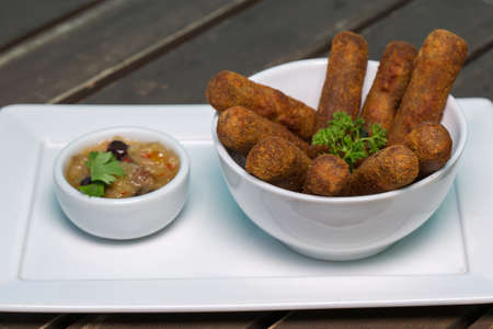 Meat croquettes with sauce on wooden table.In Brazil called croquete de carne. Brazilian snack