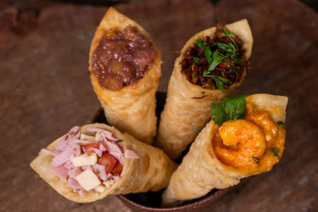 Appetizer made of pastry cones, filled with various fillings.の写真素材