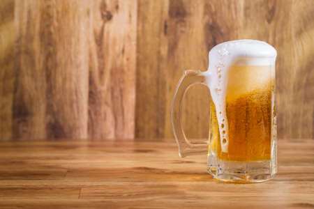 Mug of tasty beer on wooden background.の写真素材